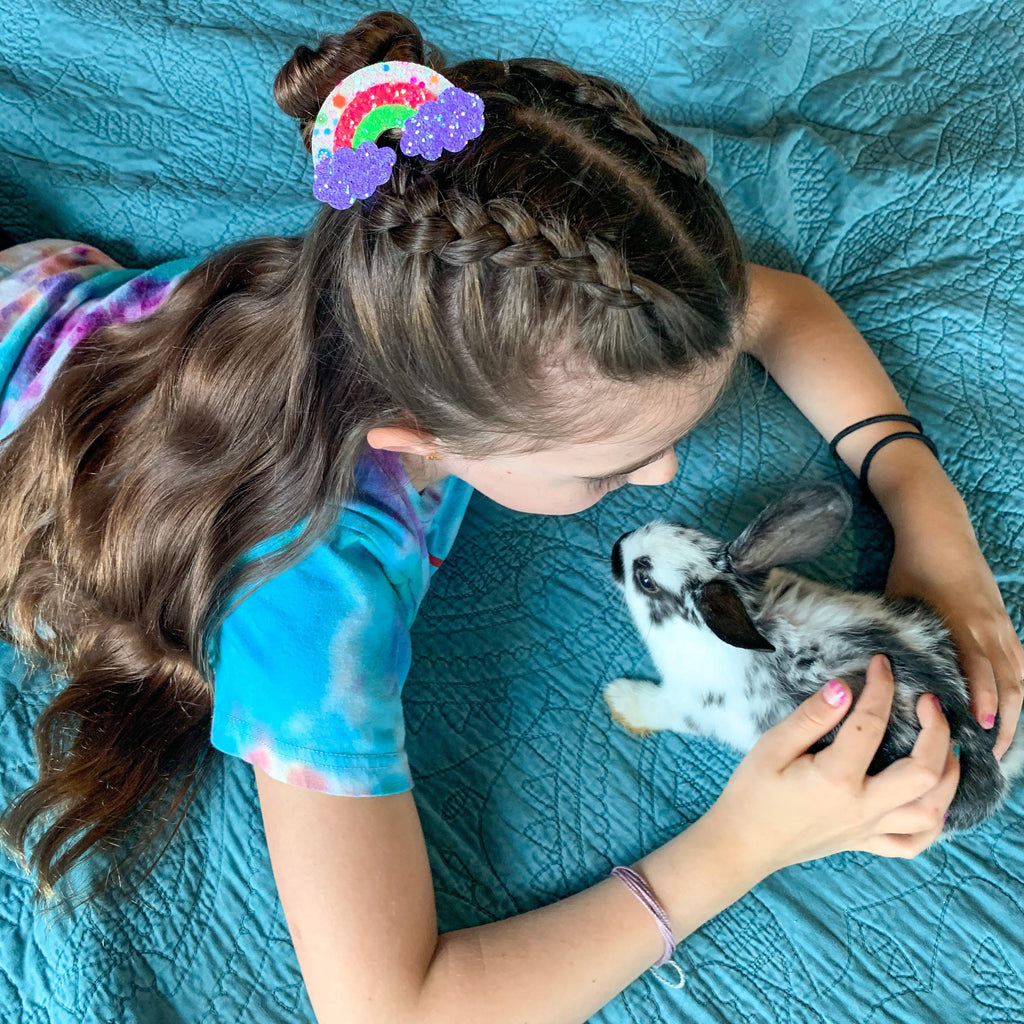 a girl wearing a glitter rainbow no slip hair clip.